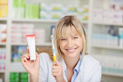 a girl holding a toothbrush and toothpaste at Dream Smile
